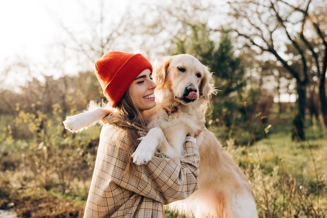 Frau hält liebevoll ihren Hund im Arm