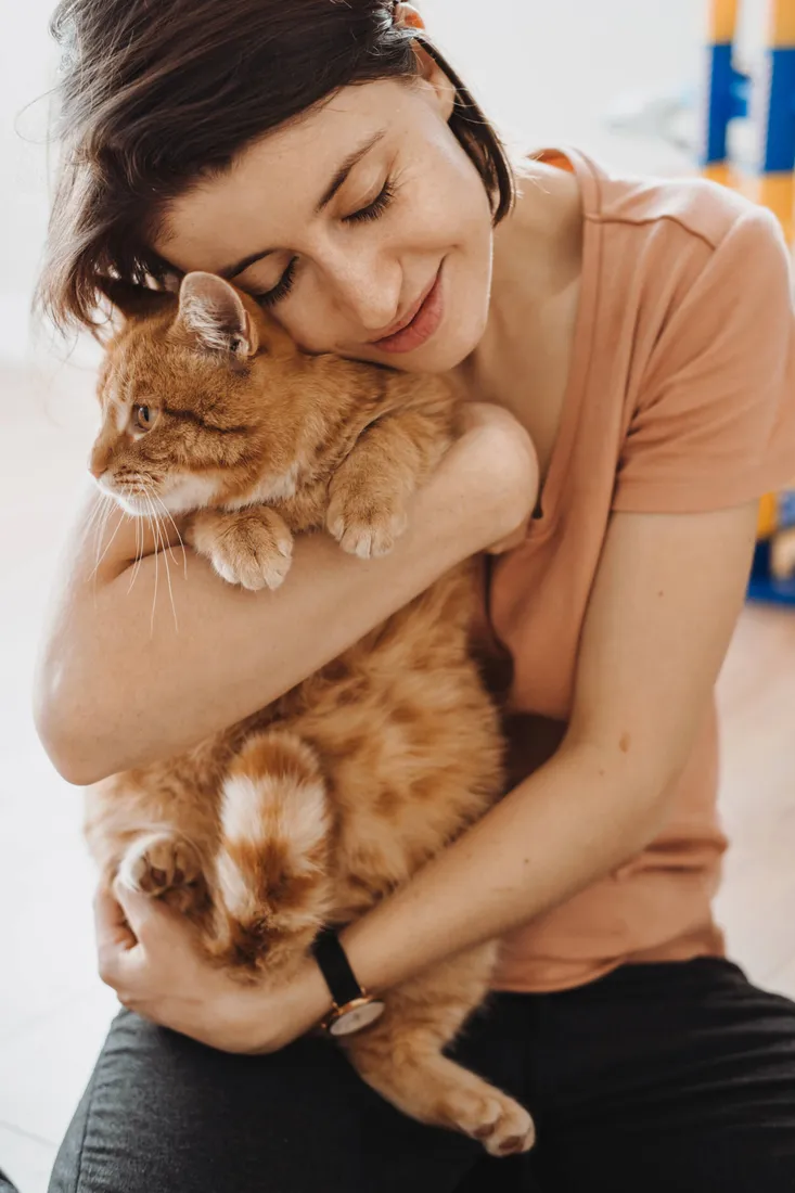 Frau umarmt liebevoll ihre Katze