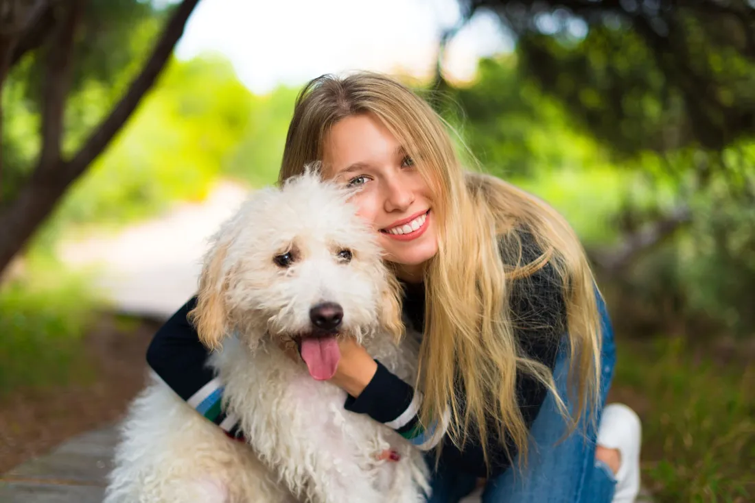 Hund und Frau kuscheln gemeinsam