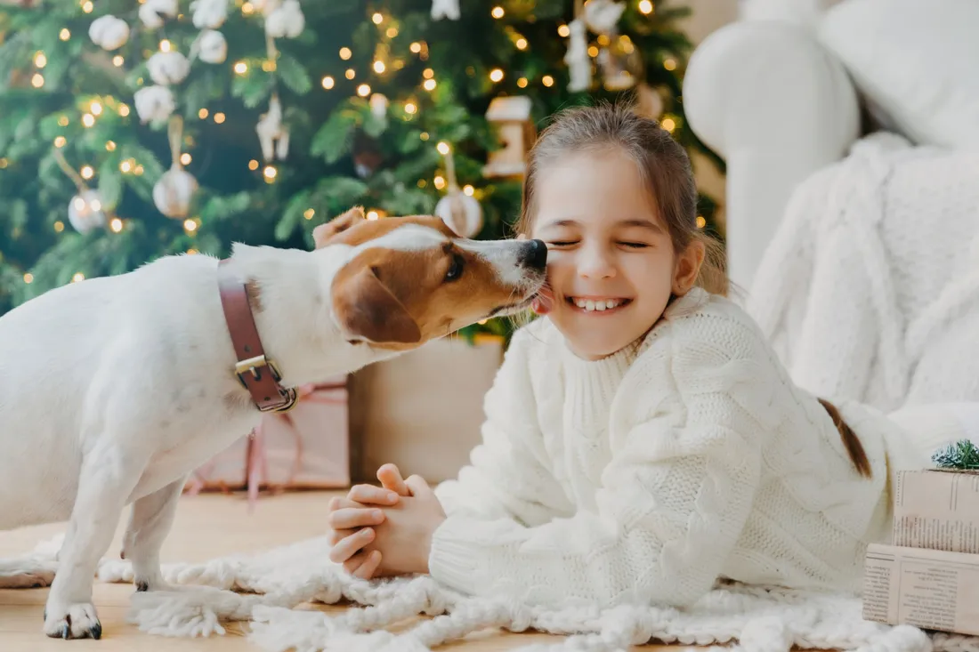 Mädchen kuschelt mit einem Hund