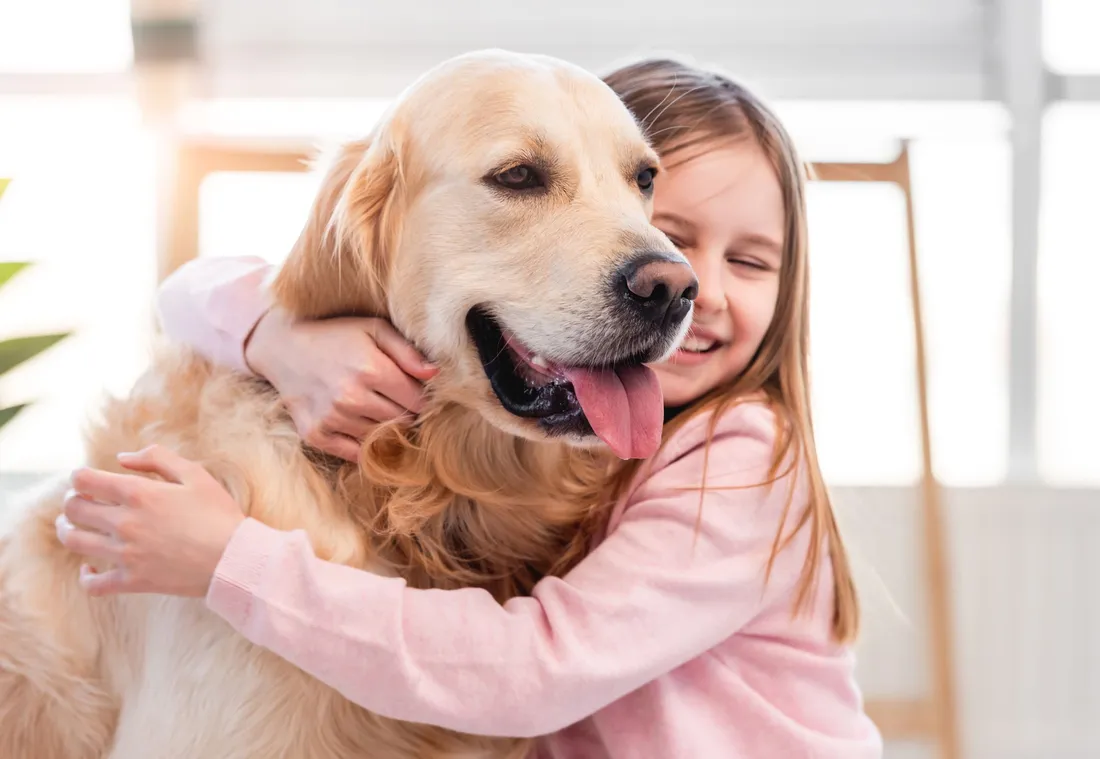 Mädchen umarmt liebevoll ihren Hund